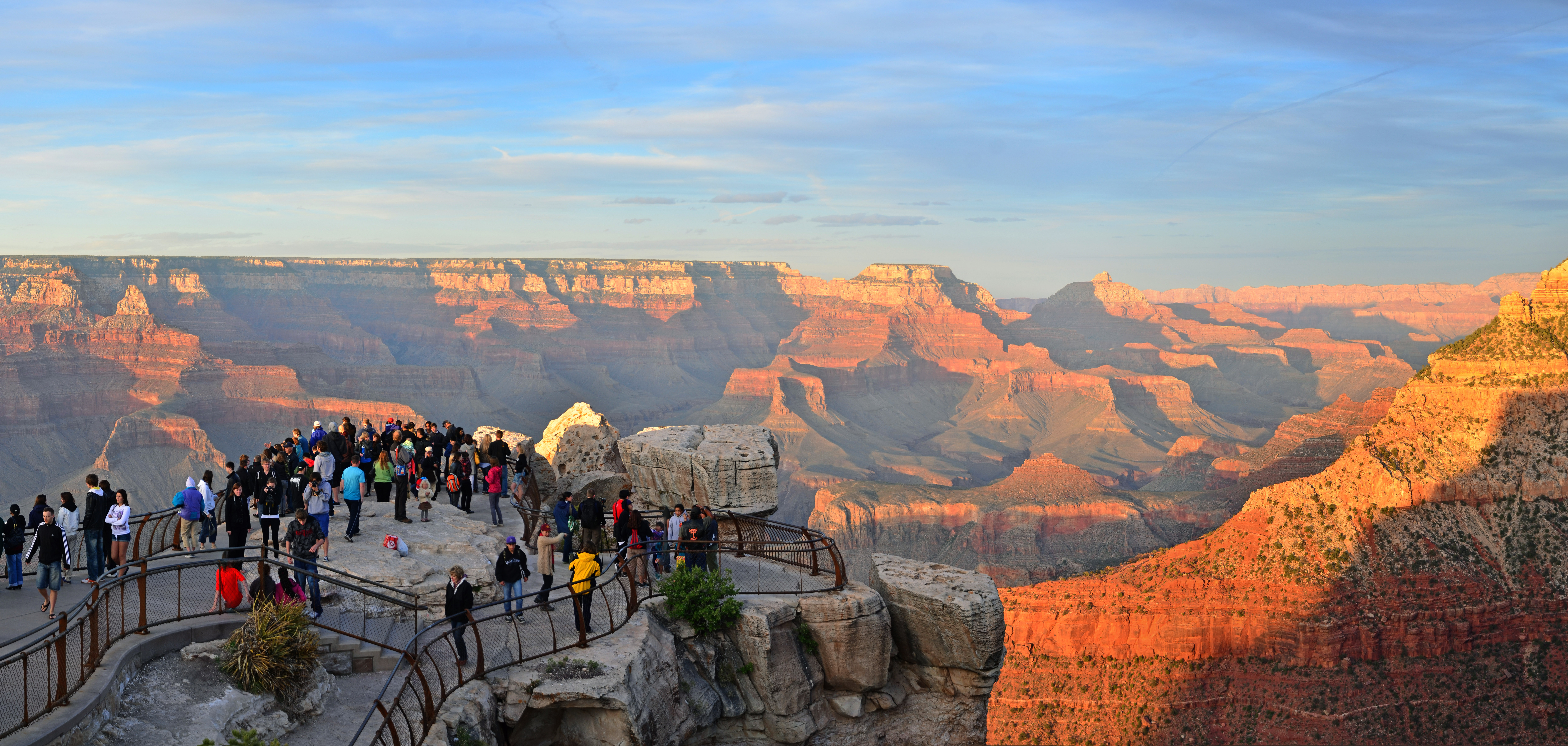 Families viewing the Grand Canyon from a paved South Rim overlook in Arizona