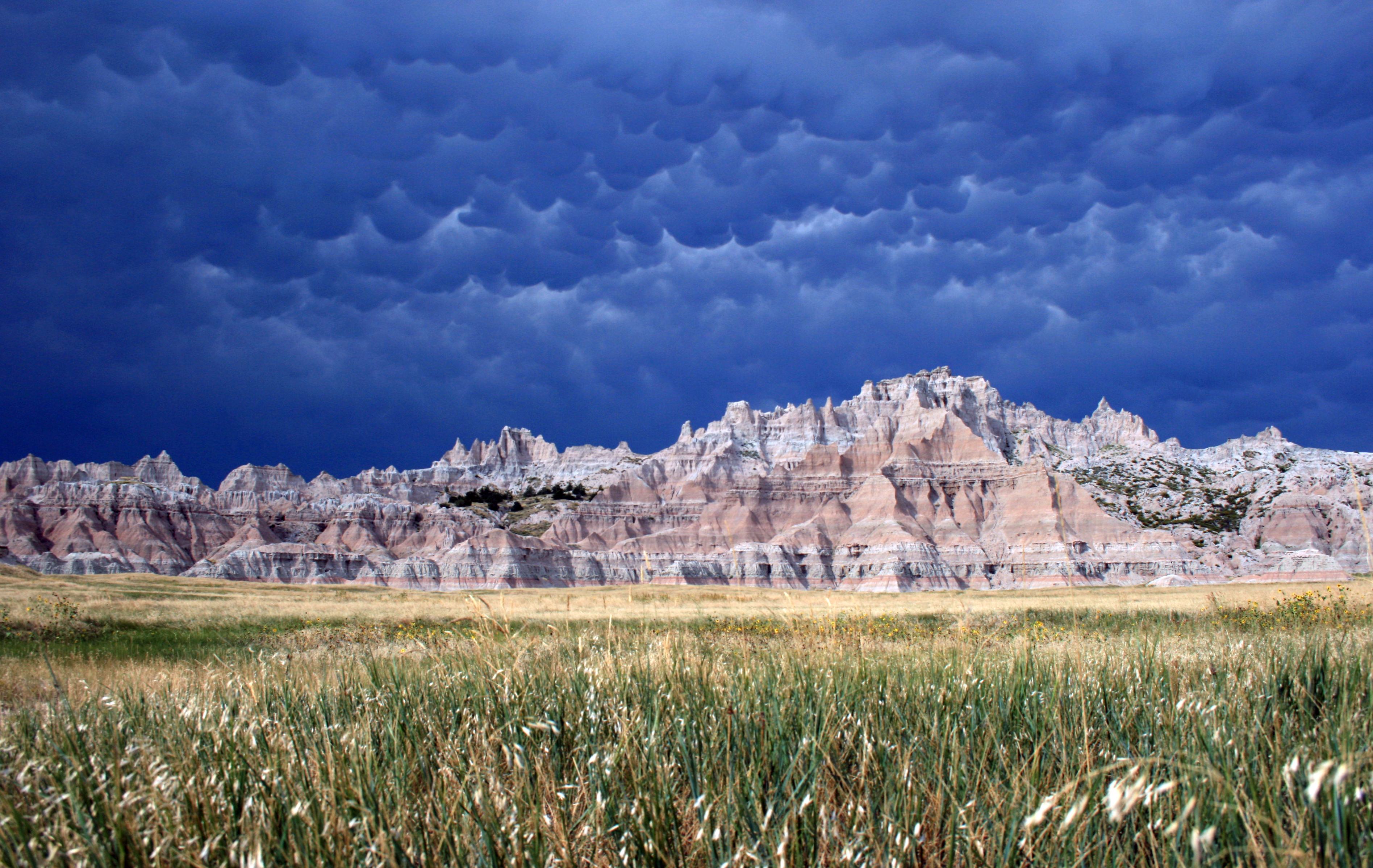 Layered tan and red rock spires of the Badlands Wall glowing at sunrise in South Dakota