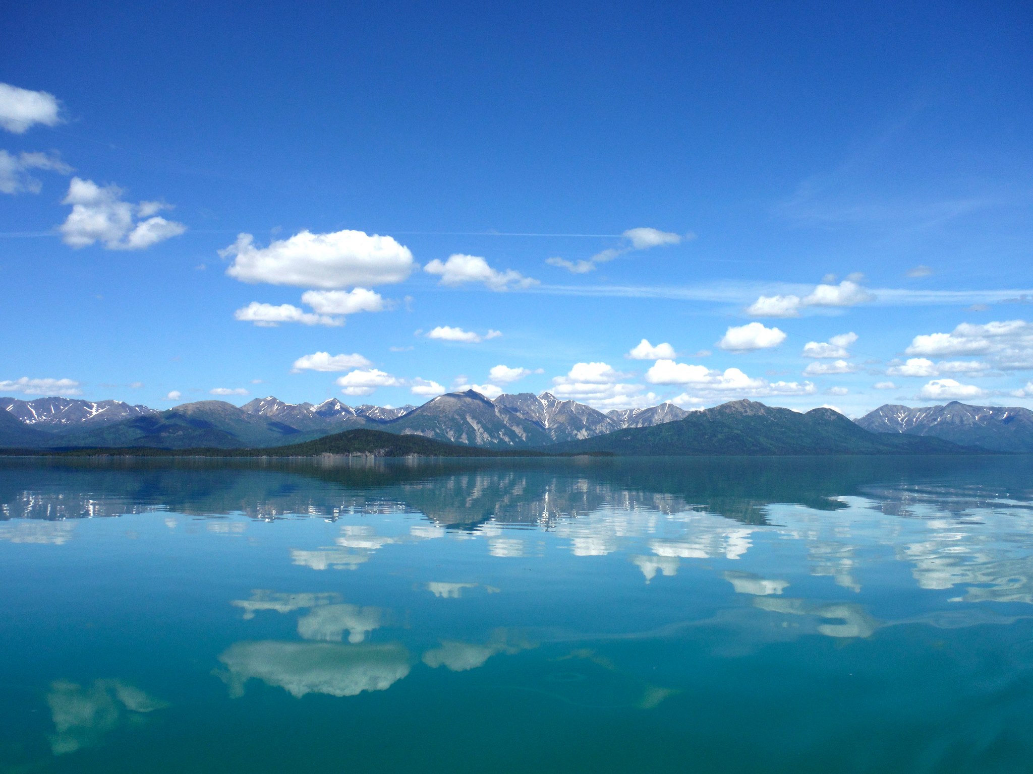 Turquoise water of Lake Clark below snow-dusted peaks in Lake Clark National Park and Preserve, Alaska